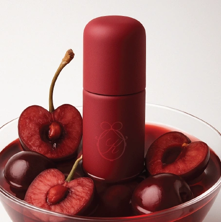 Flacon rouge au milieu de cerises.